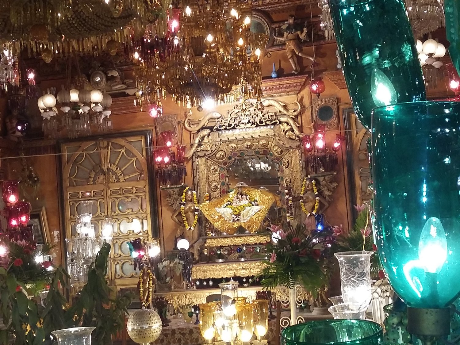 The Basanti Kamra hall at Shah Ji Temple, its gilded altar and colored Belgian glass chandeliers decorated with flowers for Basant Panchami